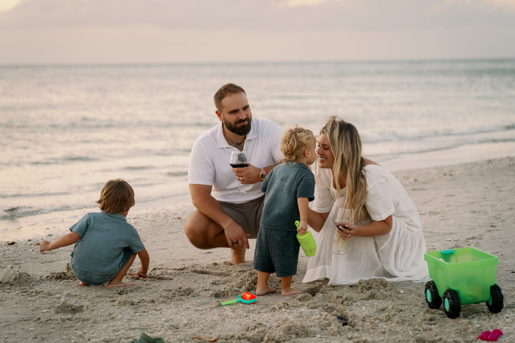 Anthony and Sami — owners of Wanderlust Photography — with their family on the beach at sunset